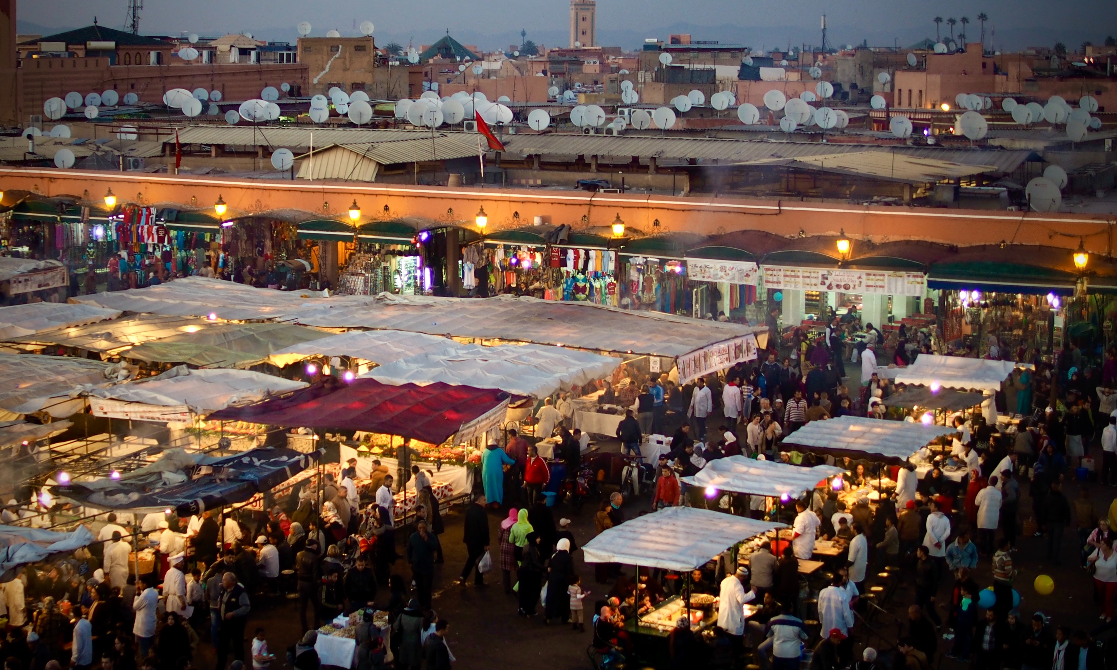 Overhead view of a busy outdoor market in the evening.